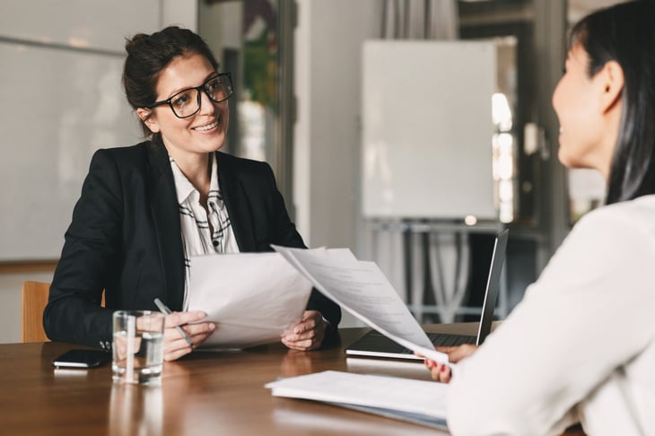 Businesswoman interviewing a job applicant and reviewing resume