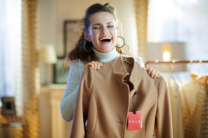 Happy shopper buying a coat on sale